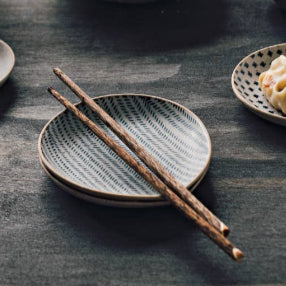 Set of ceramic dishes with food on a wooden surface