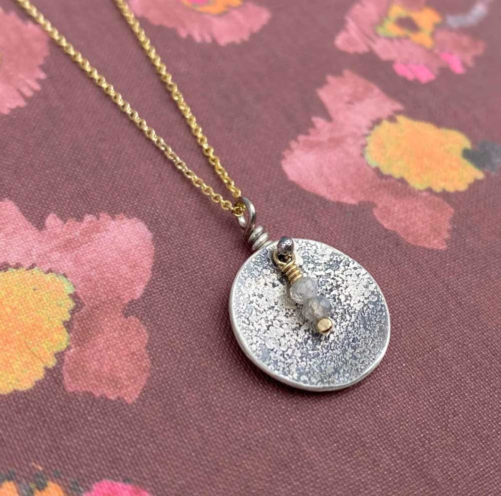 Necklace with a round silver pendant on a floral background