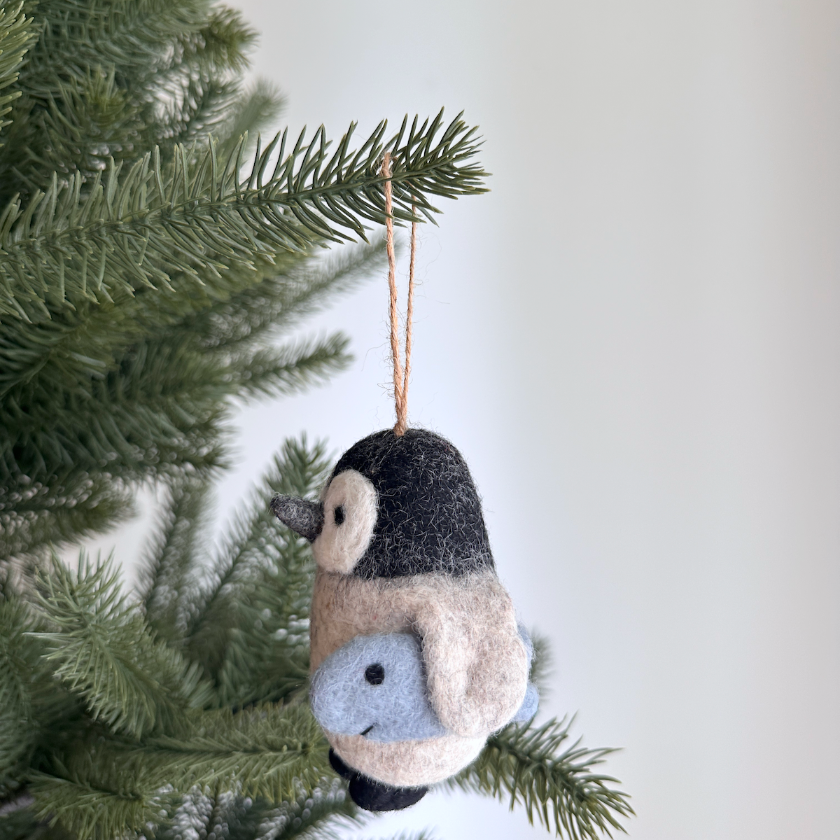 Felted bird ornament hanging on a Christmas tree branch