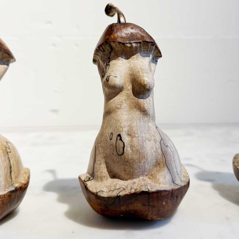 Wooden sculpture of a nude figure on a white background by Joe Lupiani