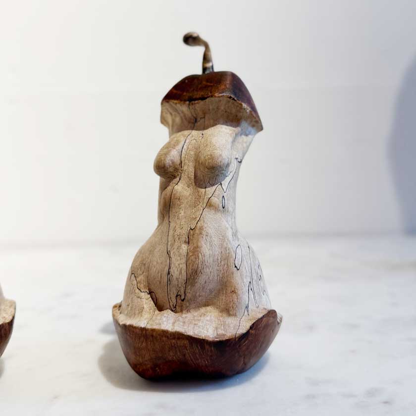 Wooden sculpture of a nude figure on a white background by Joe Lupiani