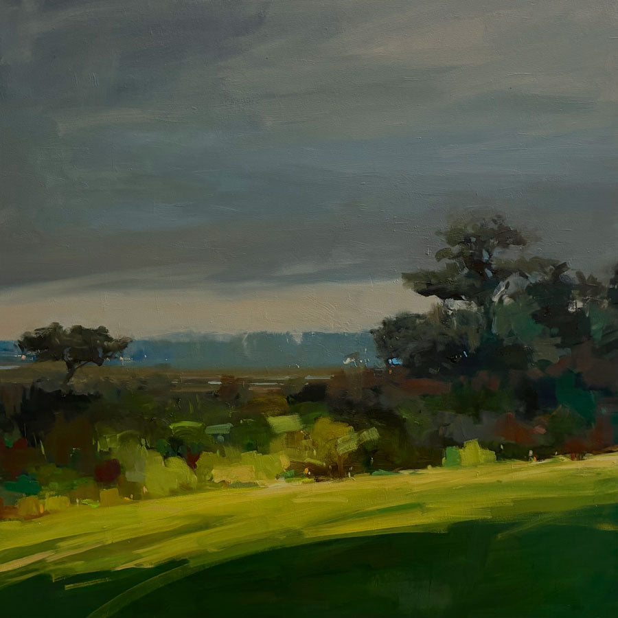 Original painting by VT artist Julia Jensen featuring an impressionistic landscape painting featuring a dark, moody gray sky, a bright green foreground field, and dark trees in the distance.