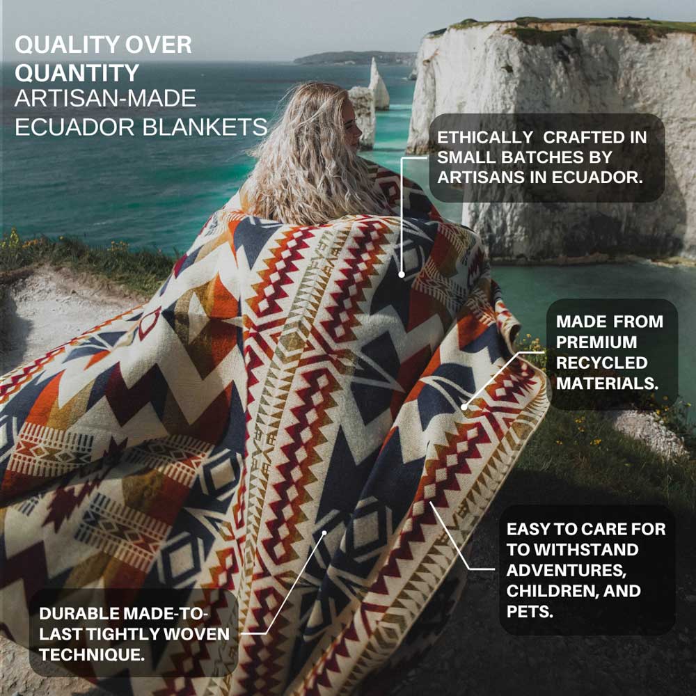 Person sitting on a cliff wearing an Ecuadorian blanket with scenic background