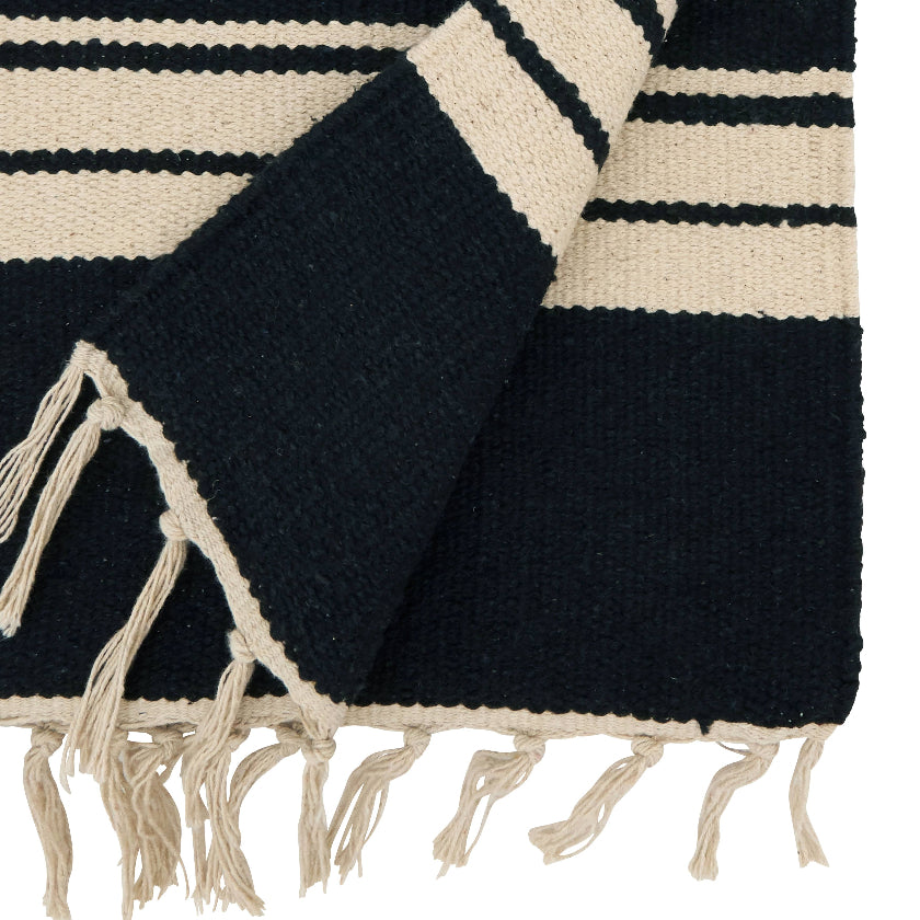 Black and beige striped blanket with tassels on a white background