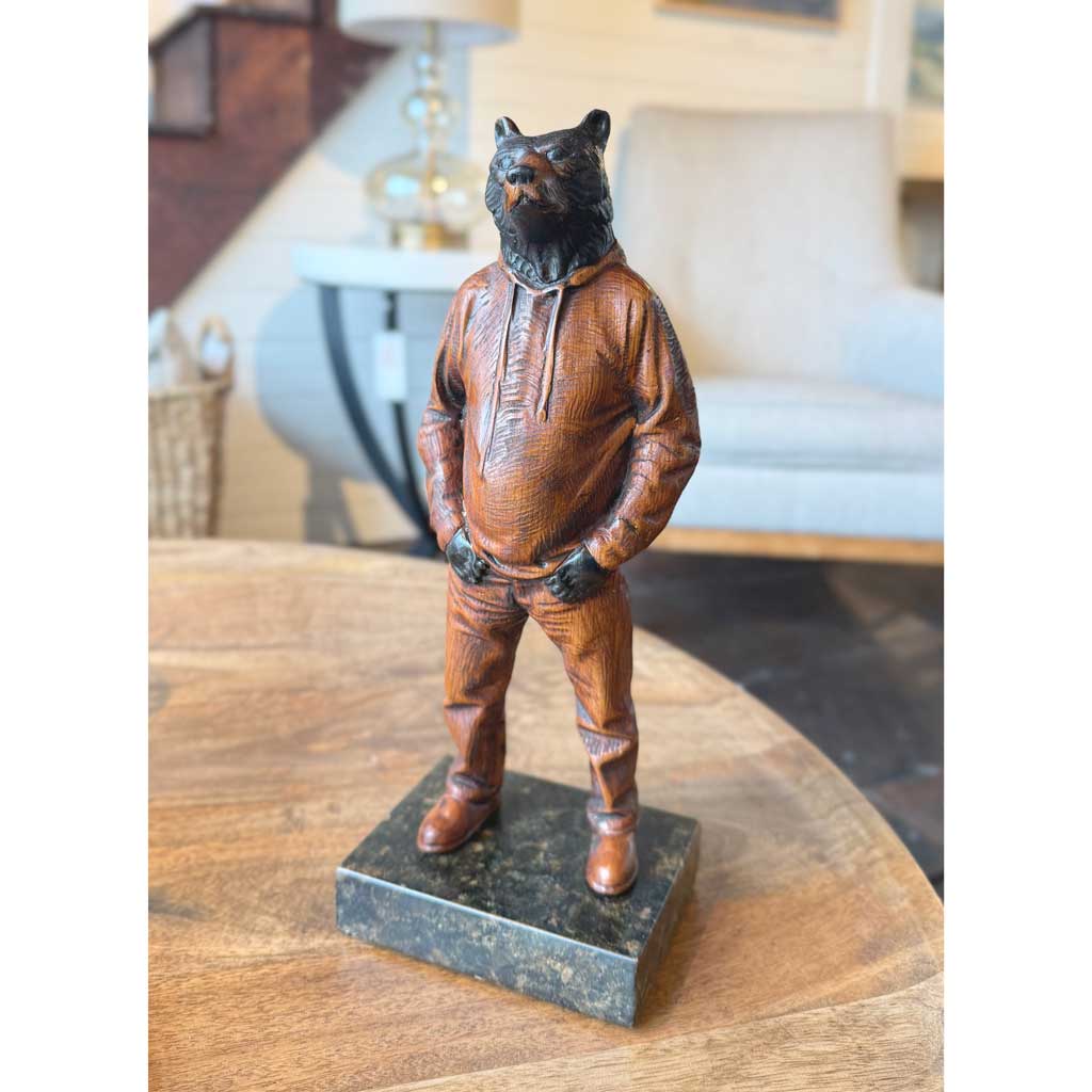 Bronze statue of a bear in a suit on a wooden table by Joe Lupiani