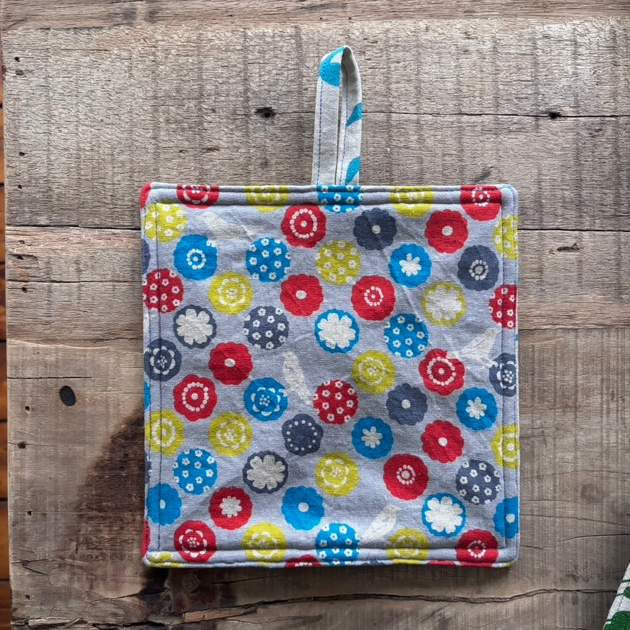 Colorful floral-patterned pot holder on a wooden surface