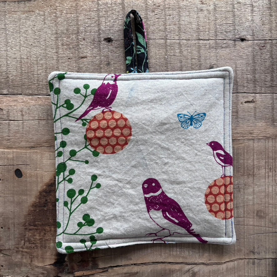 Fabric pouch with bird and butterfly design on a wooden surface