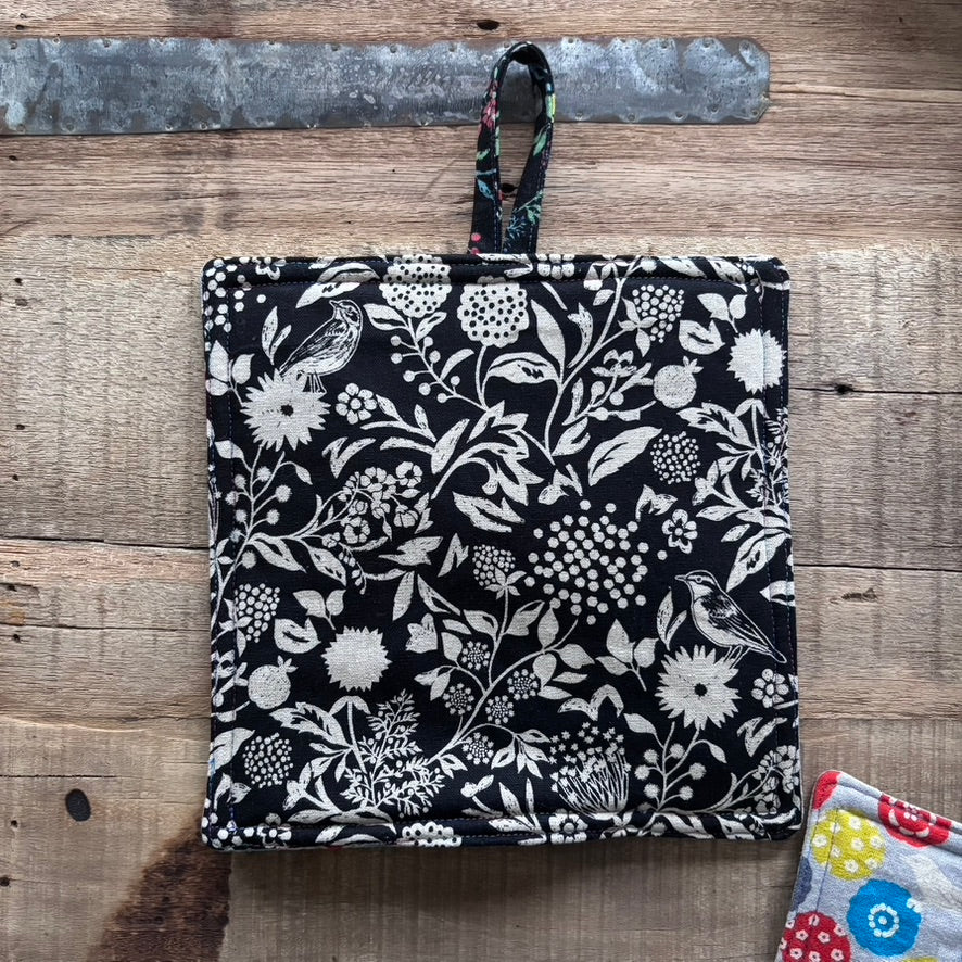 Floral patterned pot holder on a wooden surface