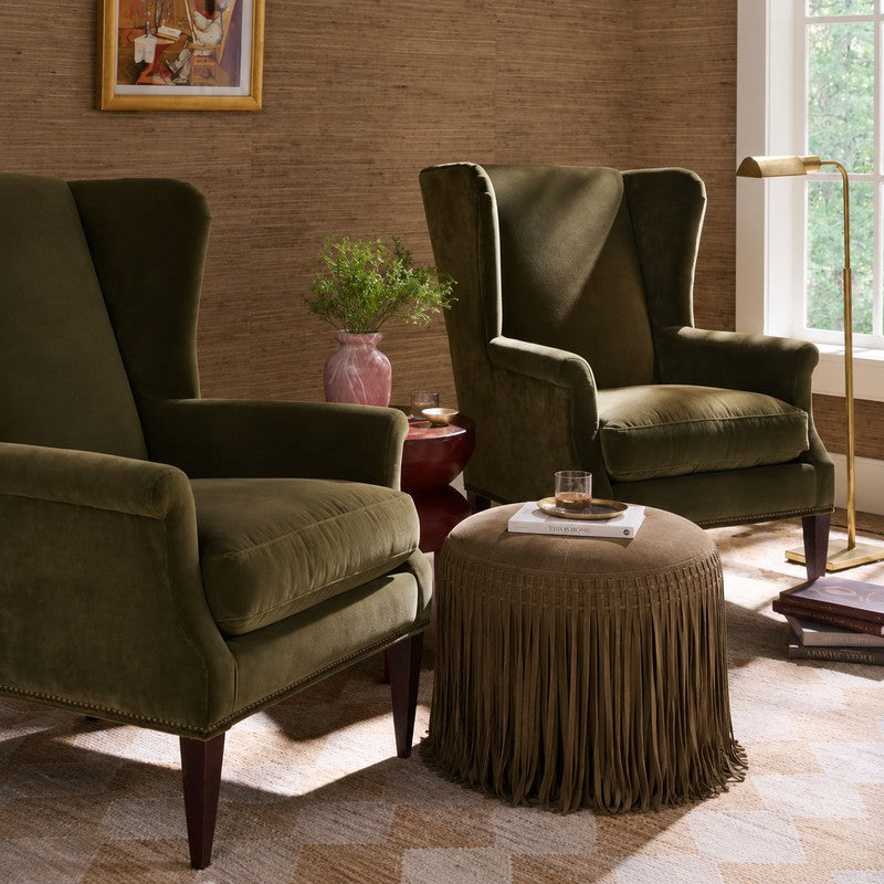 Brown suede round ottoman with long fringe detailing, a textural accent for living rooms, bedrooms and reading spaces.