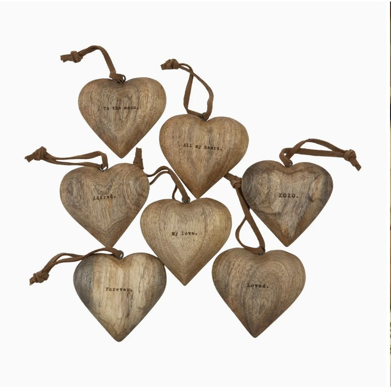 Engraved wooden heart ornaments with leather hanging loops and assorted love messages.