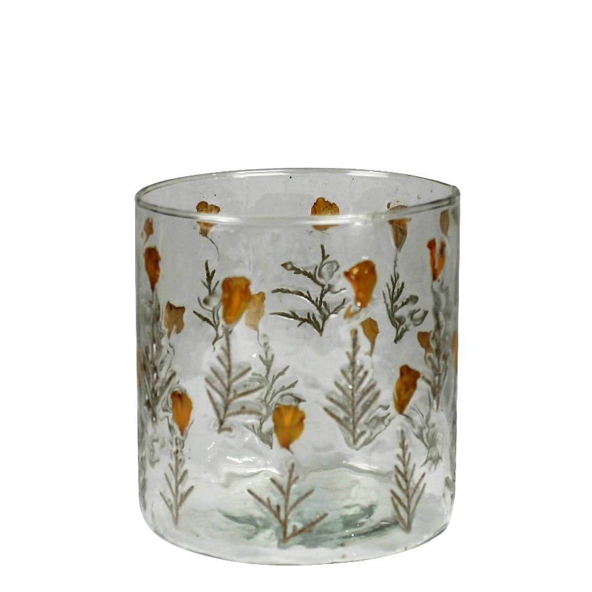 Clear glass tumbler with floral pattern on a white background