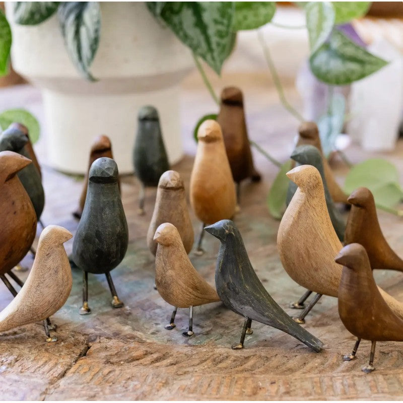 Hand-carved wooden bird sculptures with metal legs in assorted natural wood tones, sold as a set of three.