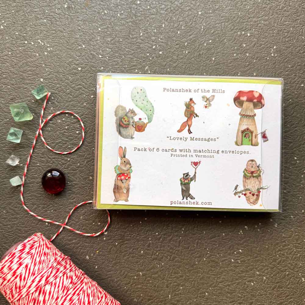 Pack of greeting cards with illustrations on a dark surface with decorative elements.