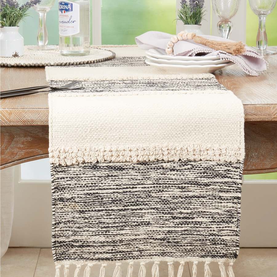 Saro Lifestyle Banded cotton table runner in black and natural with fringed edges, styled on dining table