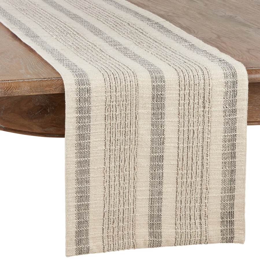 Saro Lifestyle textured striped ivory cotton table runner draped on wood dining table